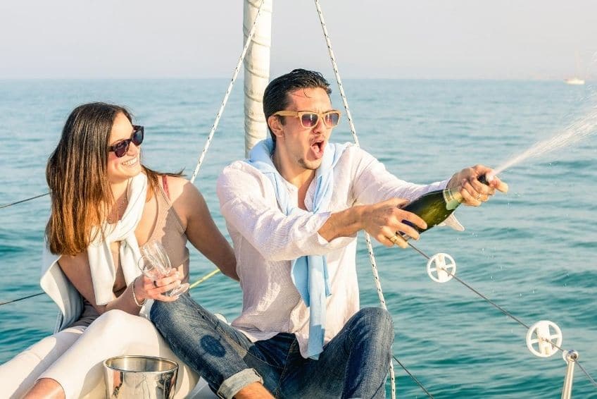 a man and woman sitting next to a body of water