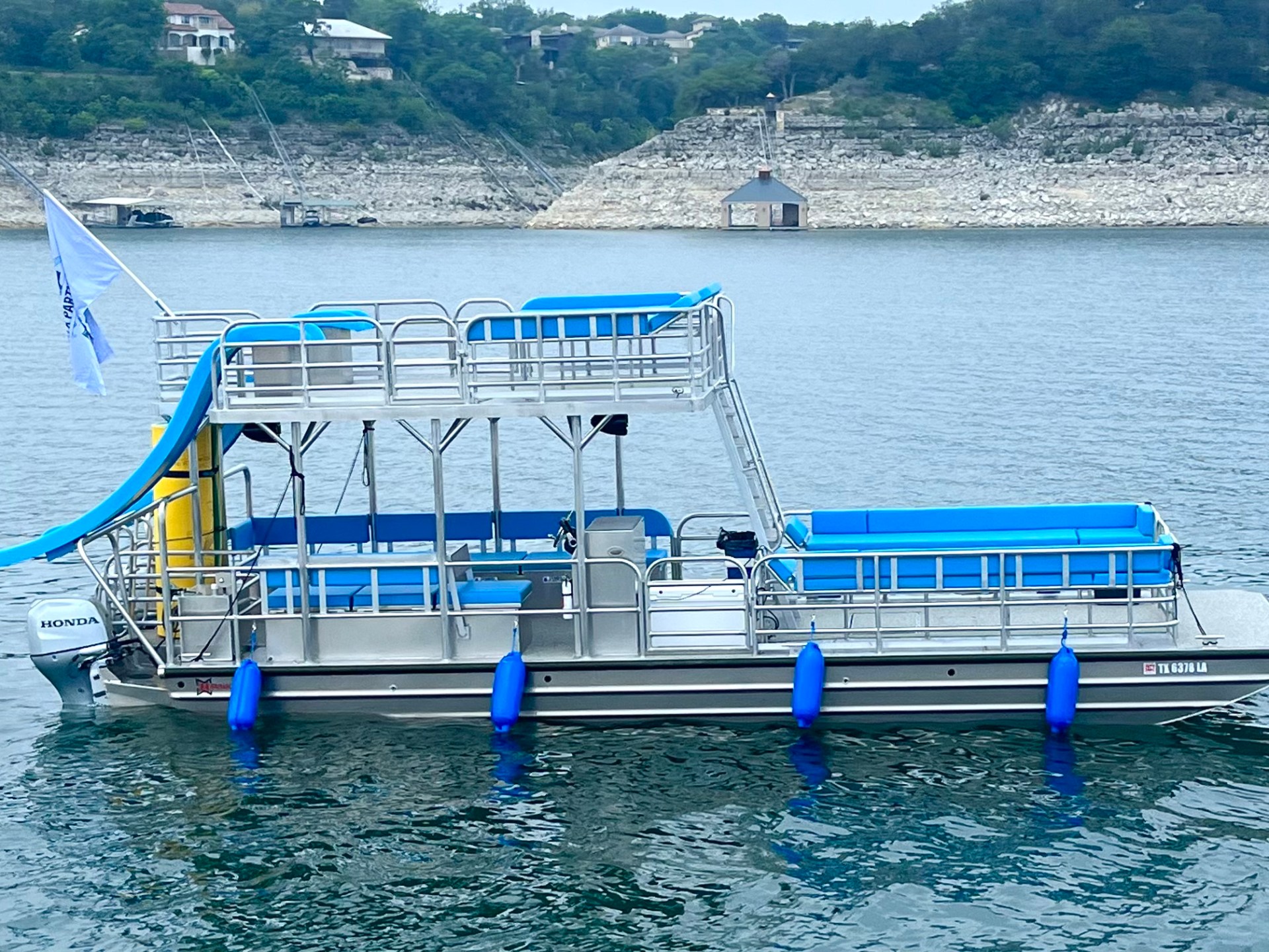 a blue and white boat sitting next to a body of water