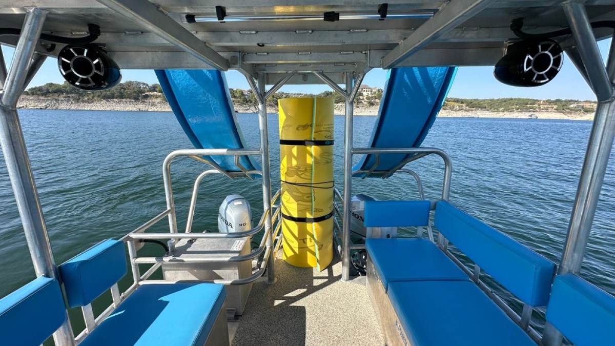 a blue and white boat sitting next to a pool of water