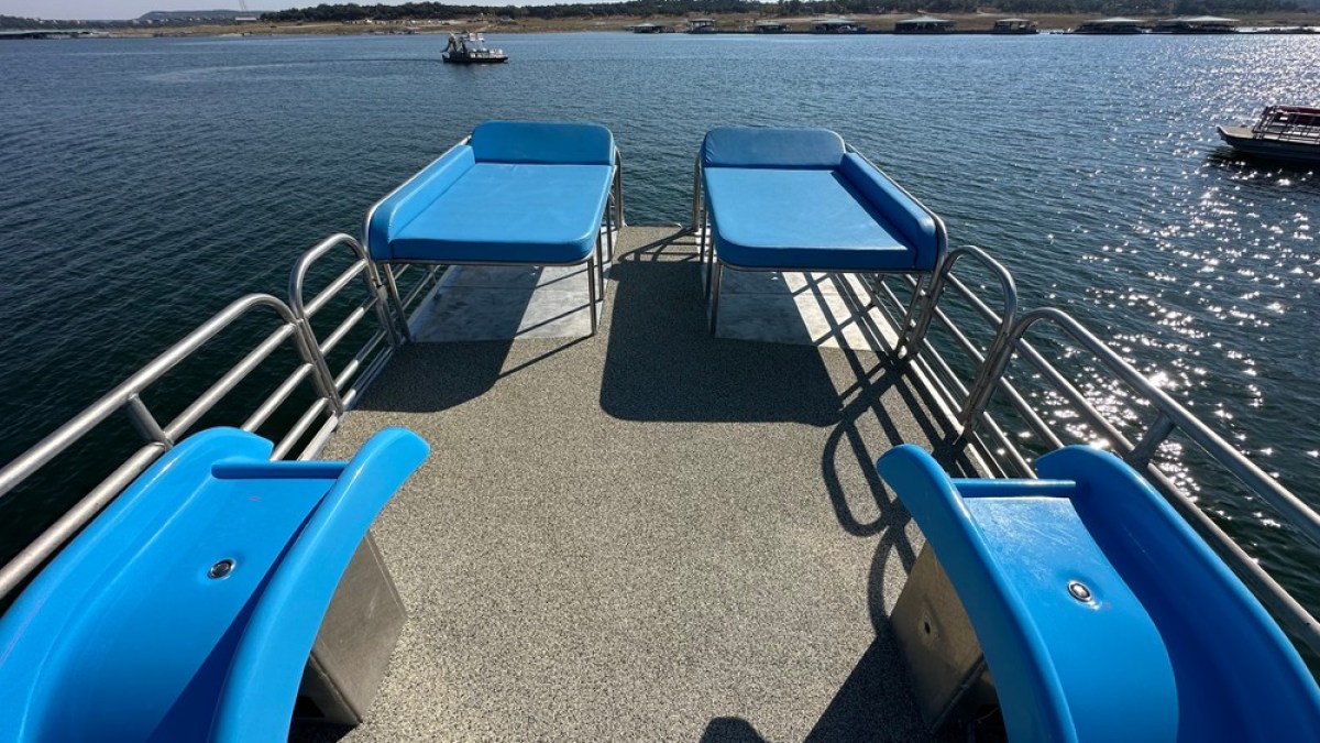 a blue and white boat sitting next to a body of water
