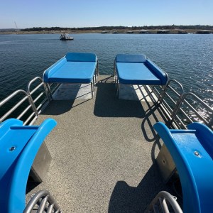 a blue and white boat sitting next to a body of water