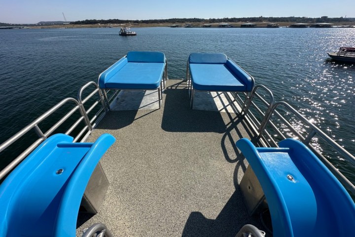 a blue and white boat sitting next to a body of water